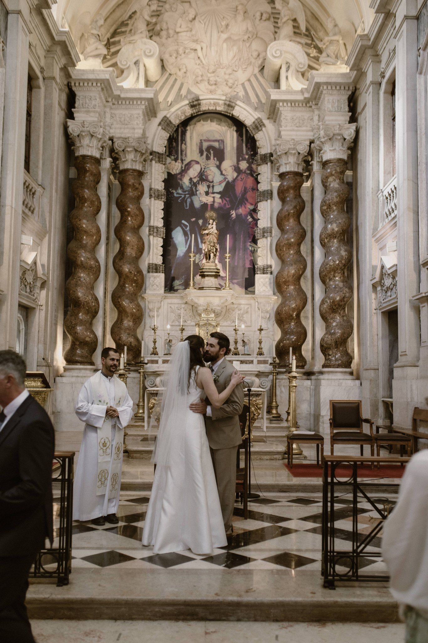 Bride and groom kiss inside a Catholic church during the ceremony of their micro wedding in Portugal
