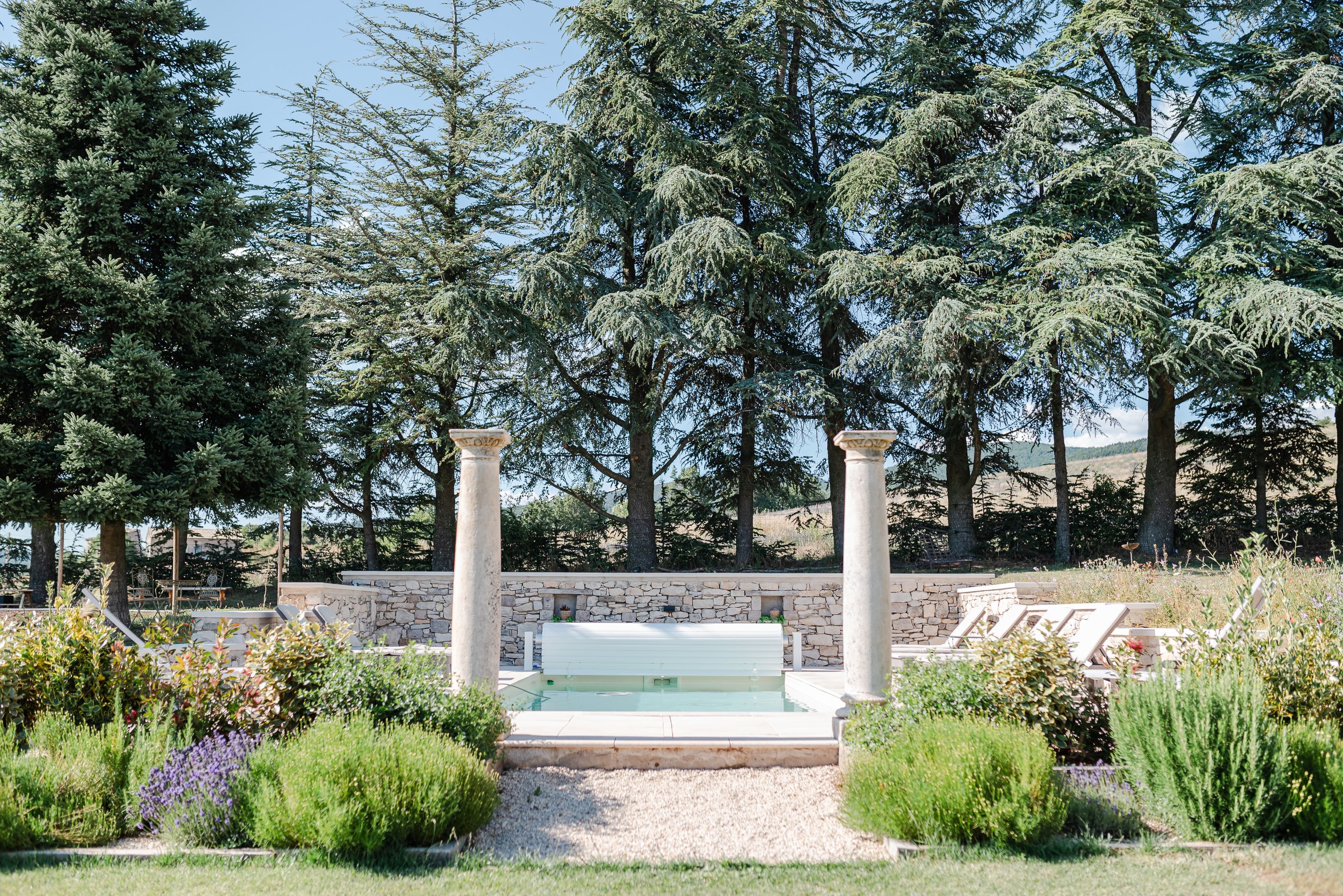 Elegant garden pool surrounded by lavender and trees at a venue for an intimate wedding in France
