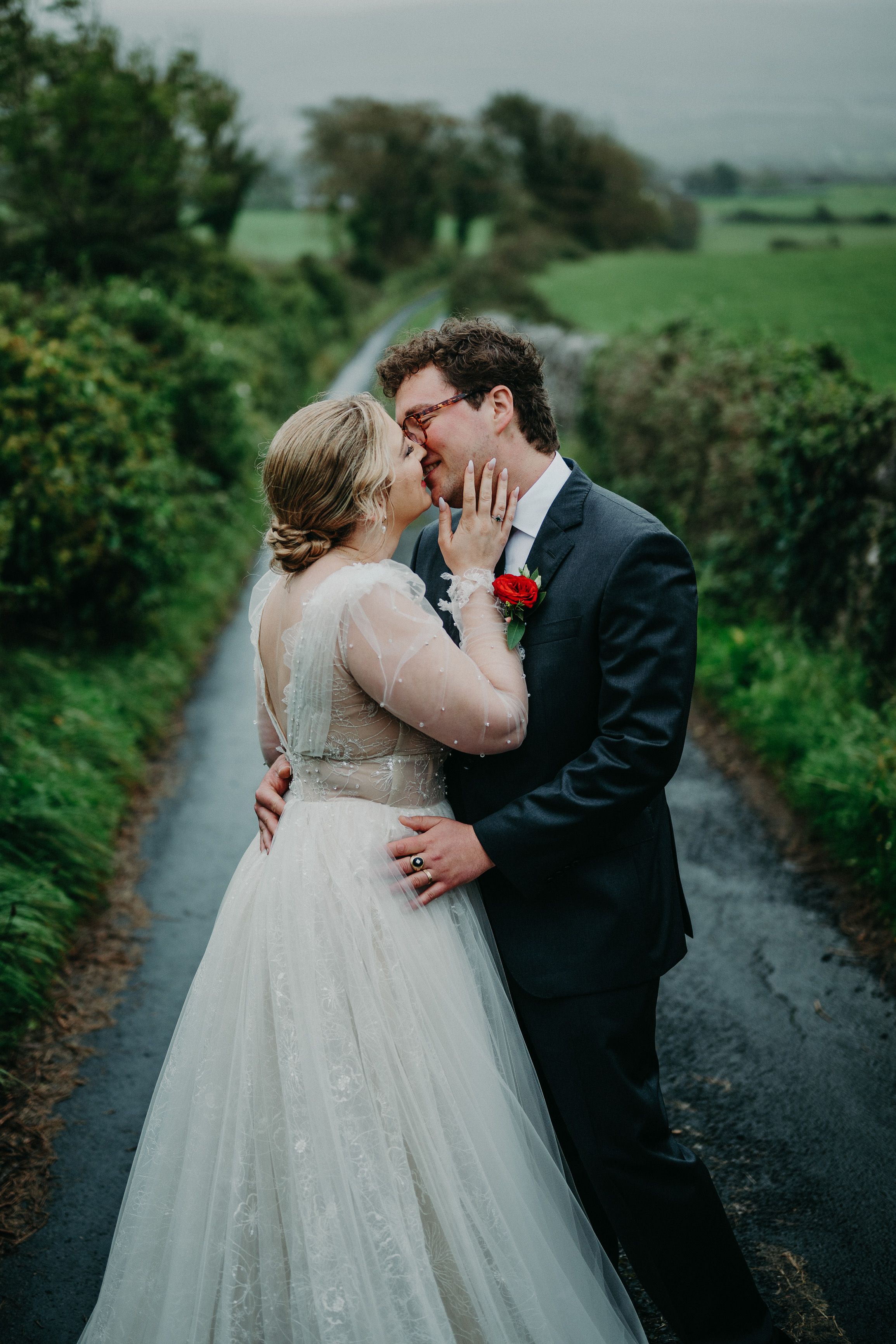 Bride and groom sharing a kiss on a country lane after their intimate wedding in Ireland