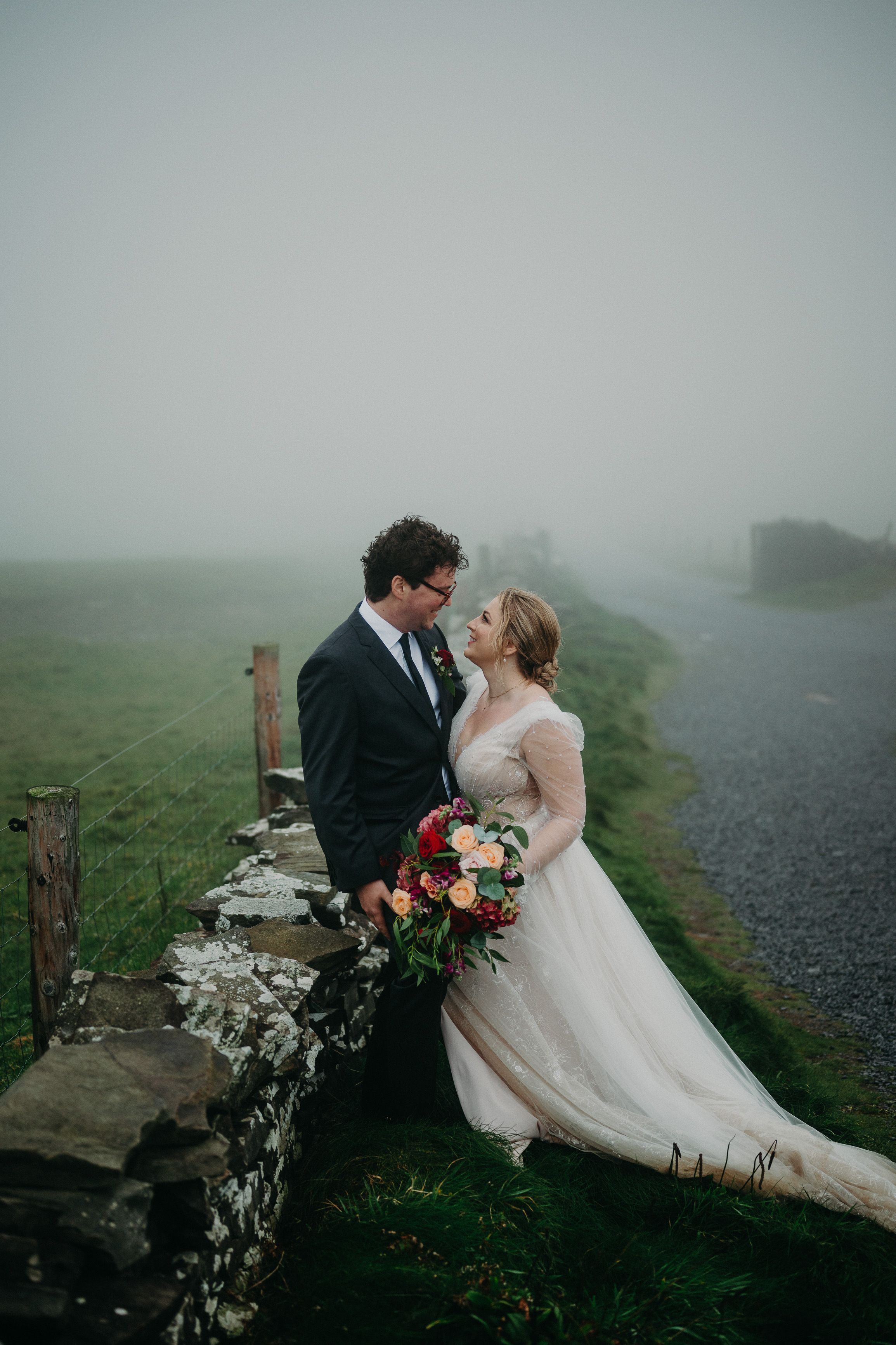 Romantic portrait of bride and groom beside a stone wall during an intimate wedding in Ireland