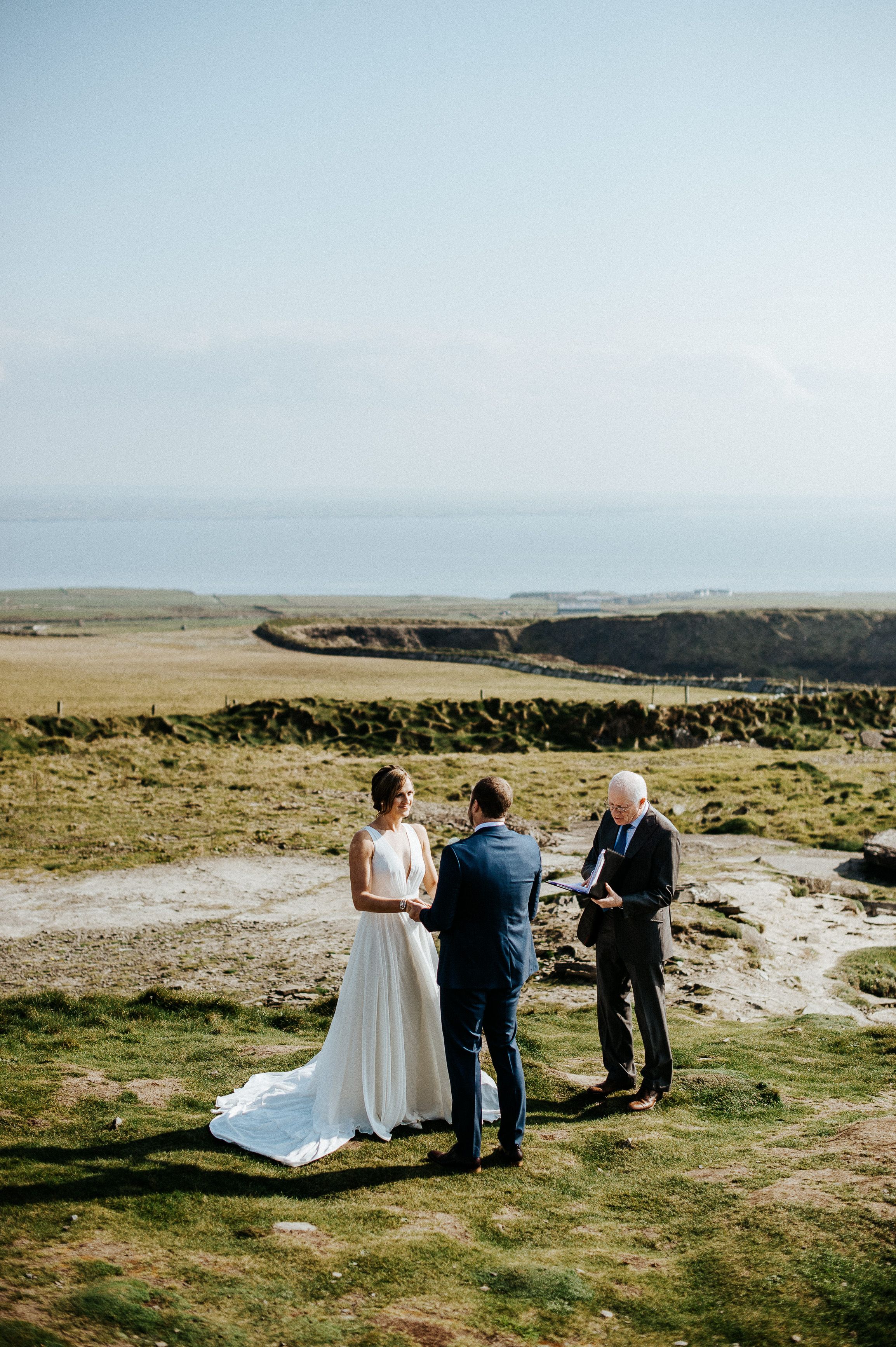 Couple exchanging vows on dramatic coastal cliffs during a small wedding in Europe