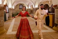 Newlyweds in Hindu wedding attire in celebratory mood, smiling as they walk inside a bodega during their destination wedding in Spain
