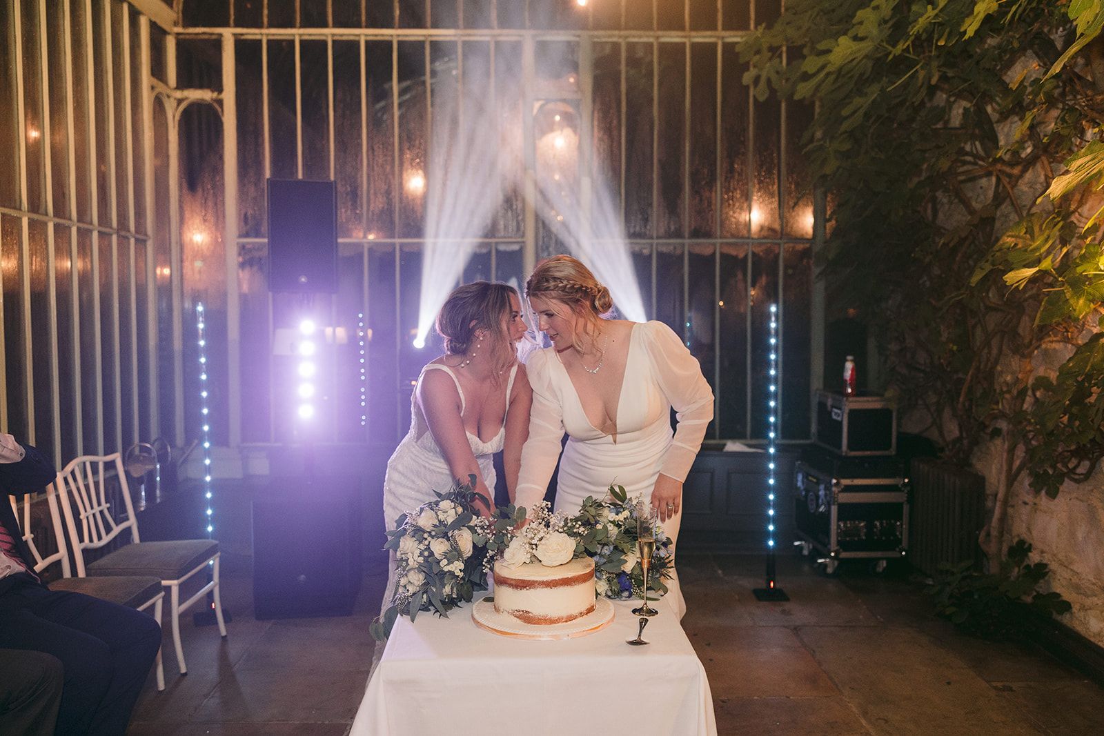 Two brides happily celebrating with lights in the background during the reception of their intimate wedding in Ireland