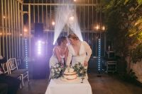 Two brides happily celebrating with lights in the background during the reception of their intimate wedding in Ireland