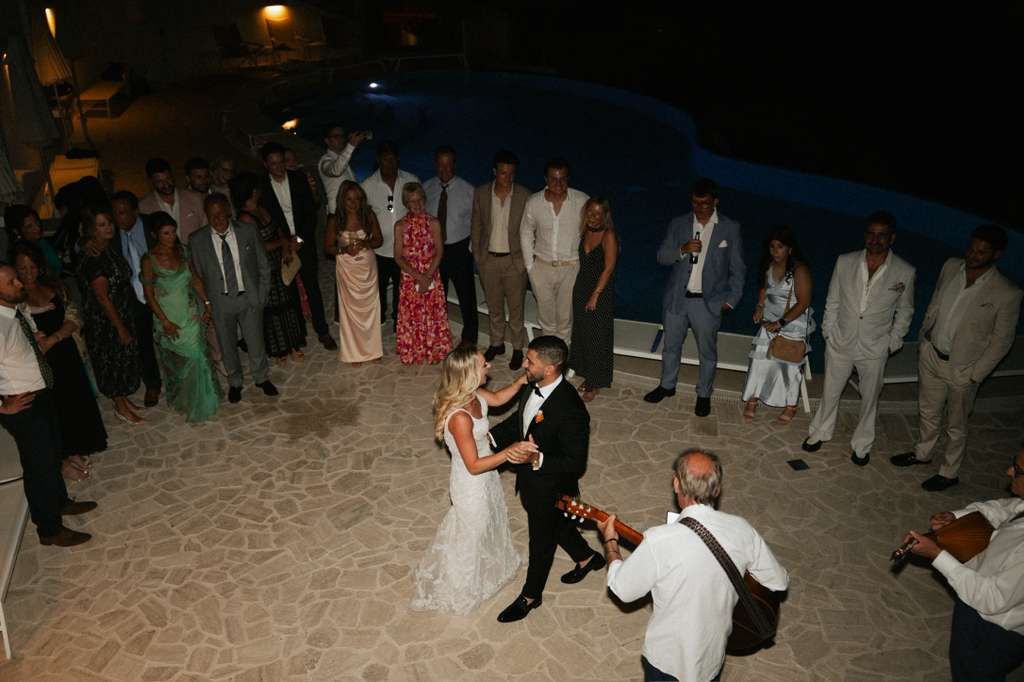 Bride and groom dancing with guests during a joyful small wedding in Italy reception