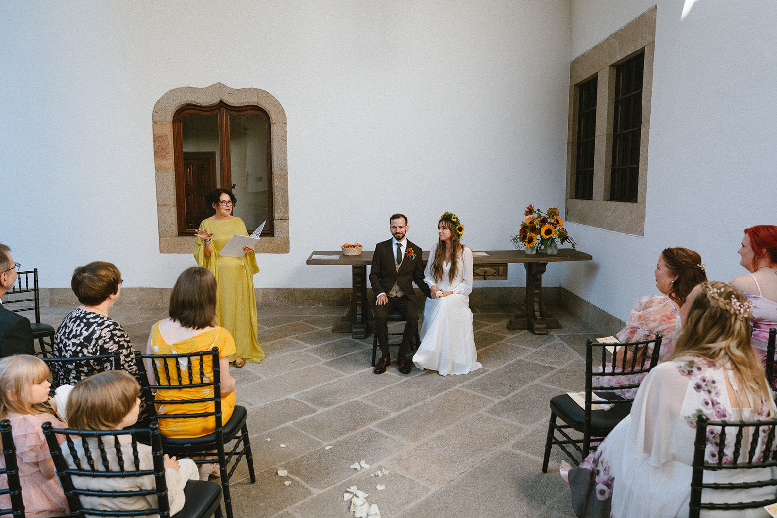 Otto and Liina-Lyydia's wedding ceremony at the Parador de Santiago, Spain's oldest hotel, bride in a sunflower crown.