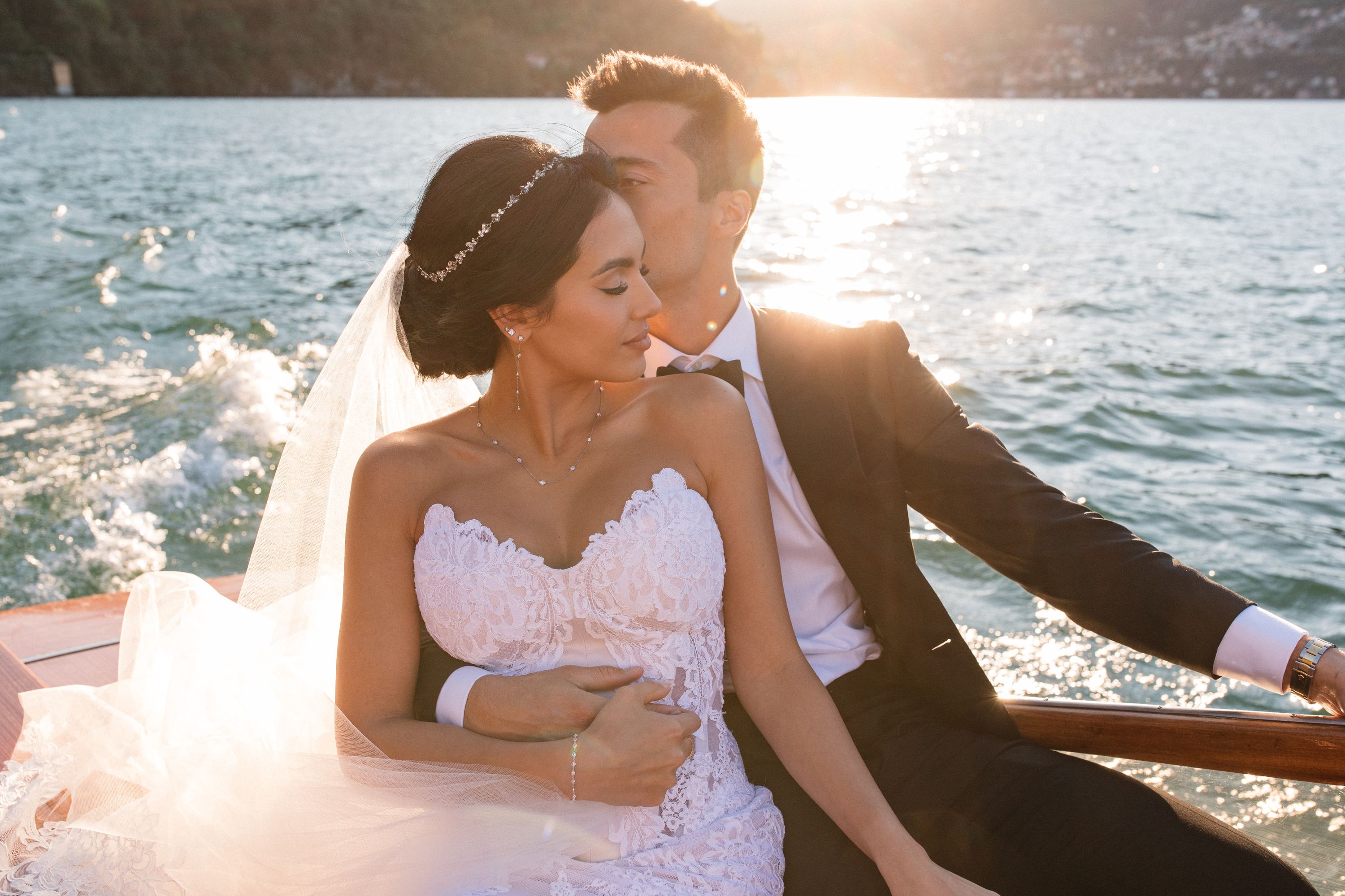 Newlyweds on a boat sailing along Lake Como during their sunset elopement in Italy