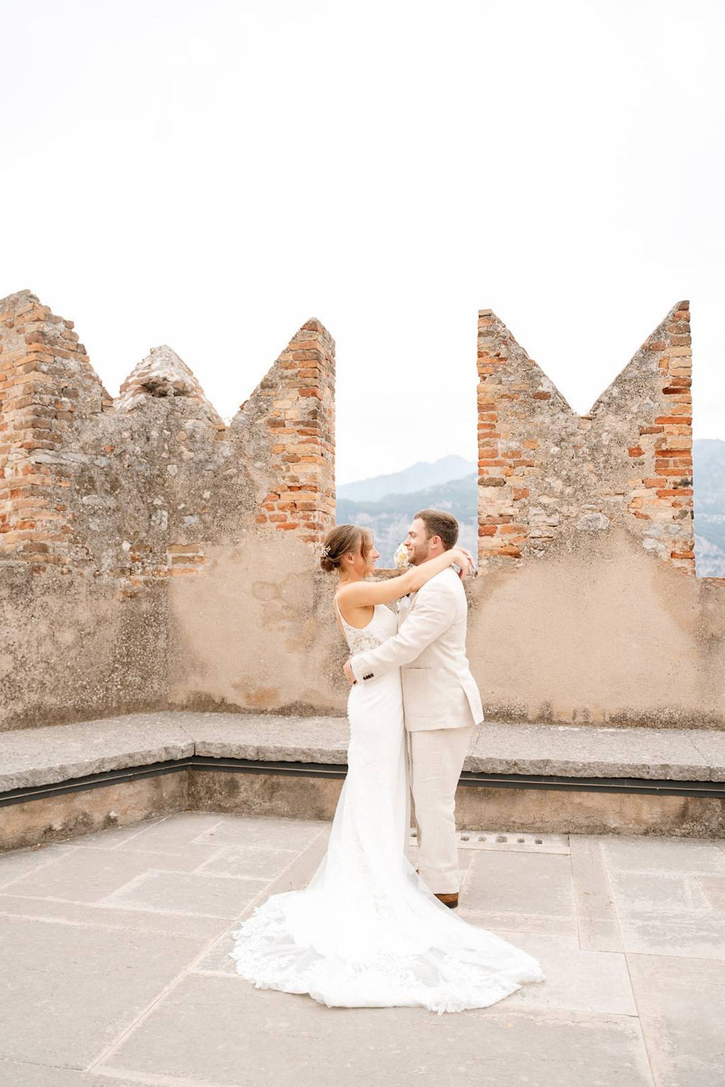Newlyweds embracing on a historic stone terrace after their small wedding in Europe