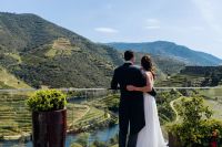Bride and groom standing on a terrace overlooking the Duoro Valley in Portugal