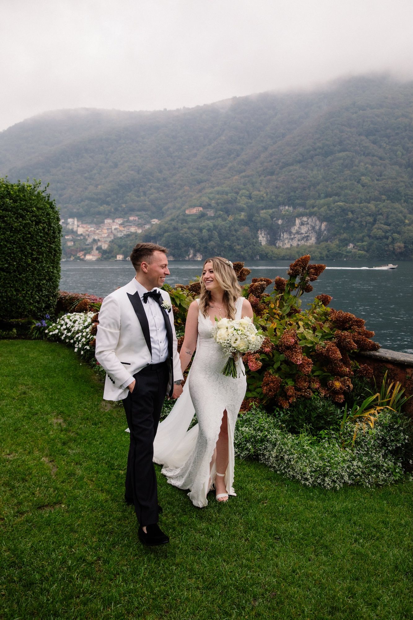 Newlyweds walking along the garden of a Lake Como villa after the ceremony of their vow renewal in Italy