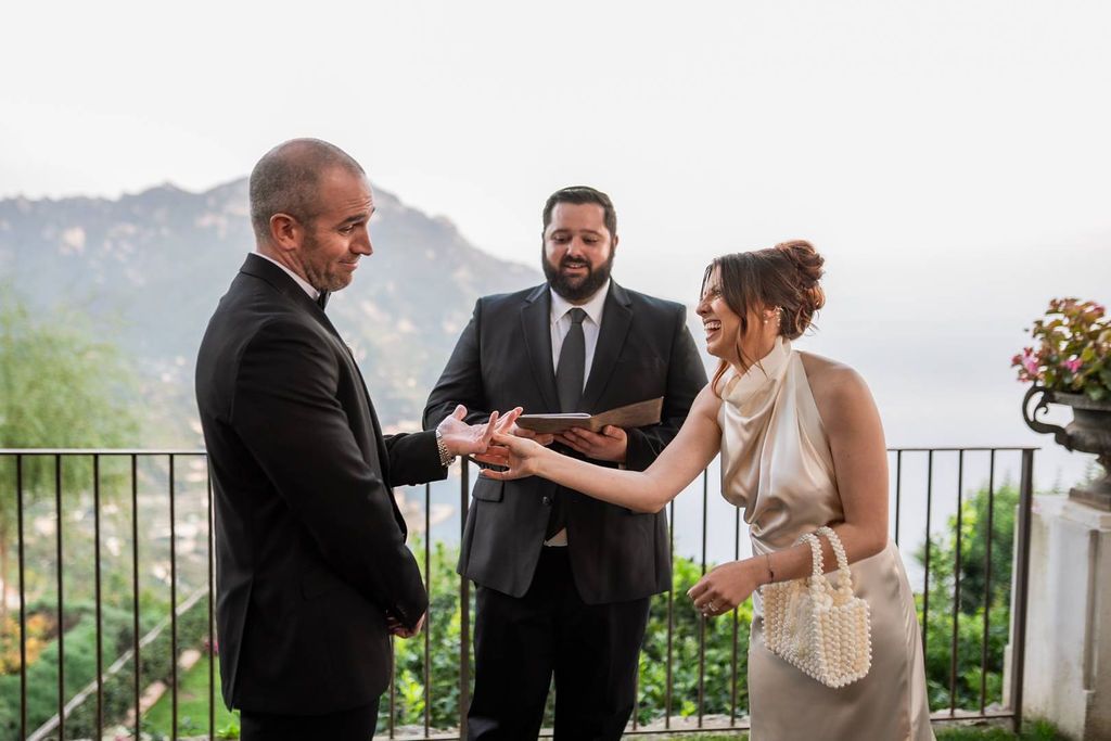 Bride and groom laughing during the ceremony of their elopement in Italy atop Amalfi Coast