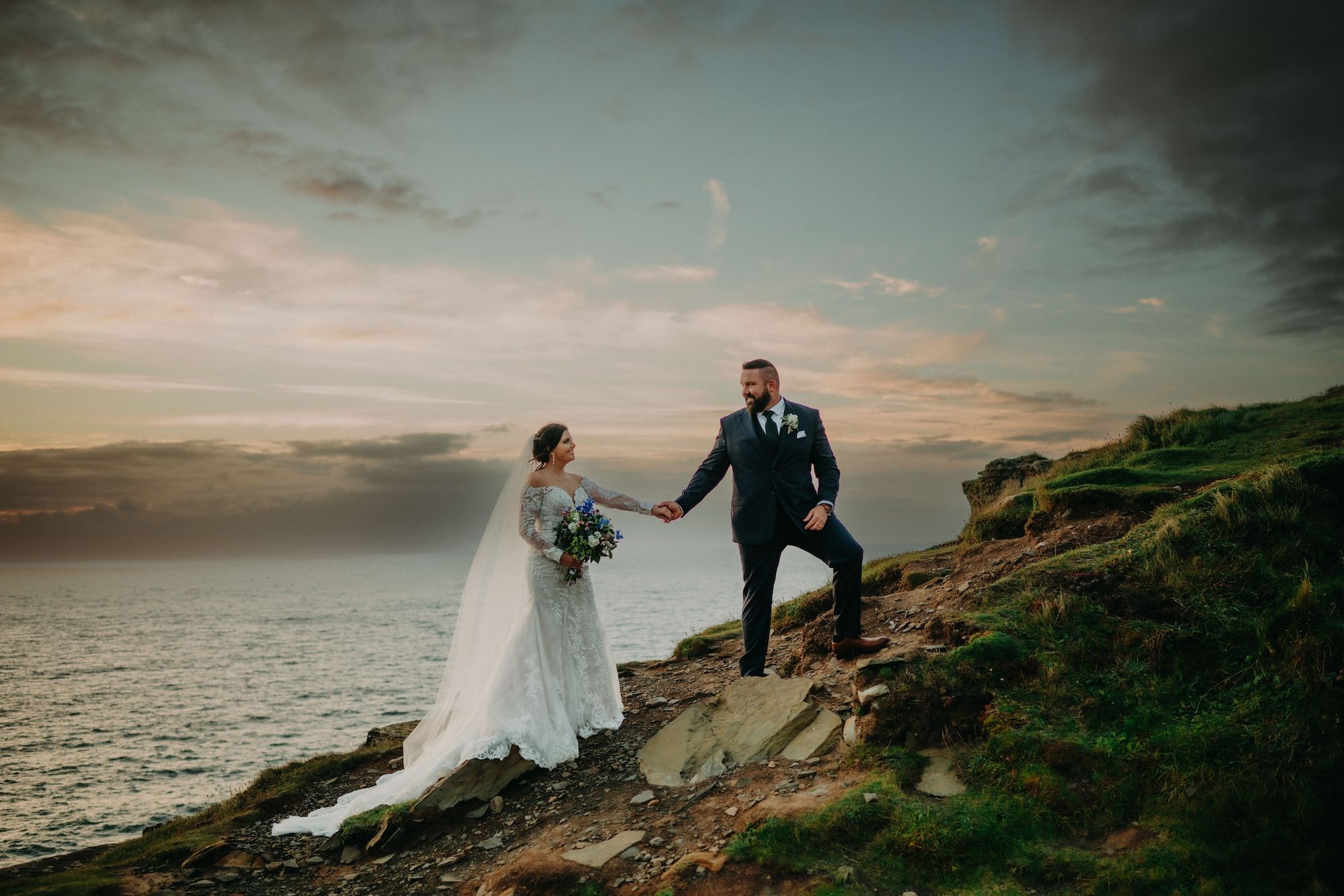 Clifftop photoshoot during sunset of an autumn destination wedding in Ireland