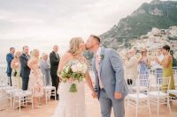 Newlyweds kissing each other after the sunset ceremony of their destination wedding in Italy atop a terrace in Amalfi Coast