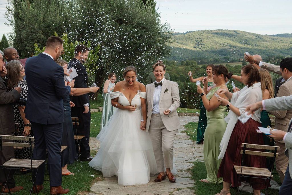 Newlyweds exiting the aisle after the outdoor ceremony of their small wedding in Italy