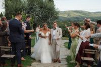 Newlyweds exiting the aisle after the outdoor ceremony of their small wedding in Italy