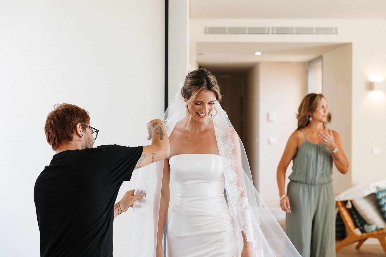 Bride in her wedding dress with a woman fixing her veil for her destination wedding in Portugal