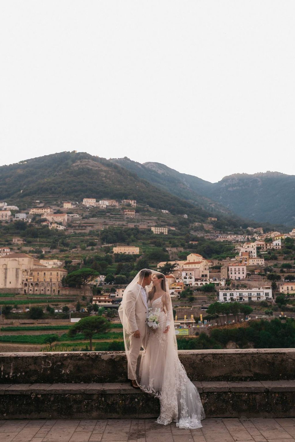 Newlyweds covered by the bride's veil during their small wedding in Italy at the heart of Amalfi