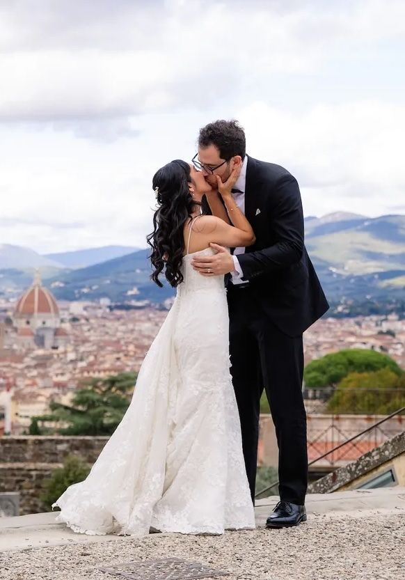 Bride and groom kissing each other during their intimate wedding in Italy with Florentine cityscape in the background
