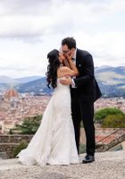 Bride and groom kissing each other during their intimate wedding in Italy with Florentine cityscape in the background