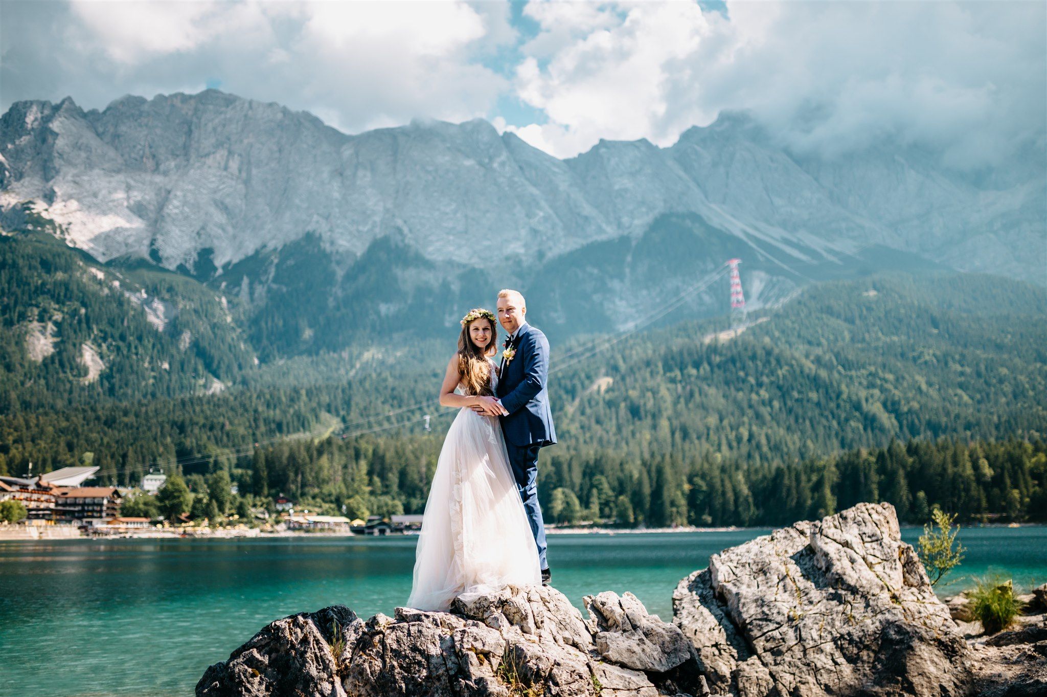 A bride and groom standing by a lake with scenic mountain views for their small wedding