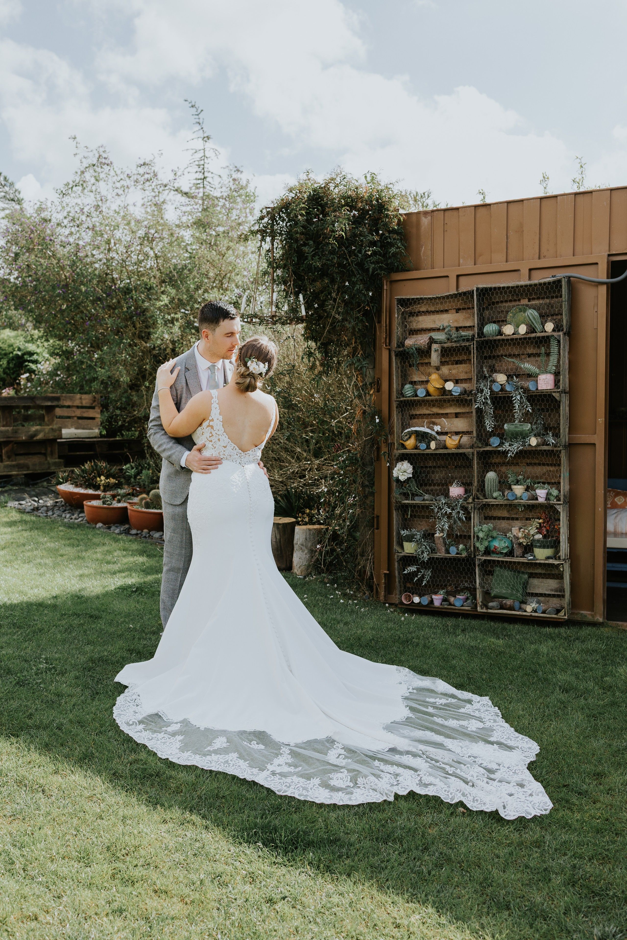 Newlyweds look at each other romantically in front of a rustic wooden plant house during their small wedding in Portugal