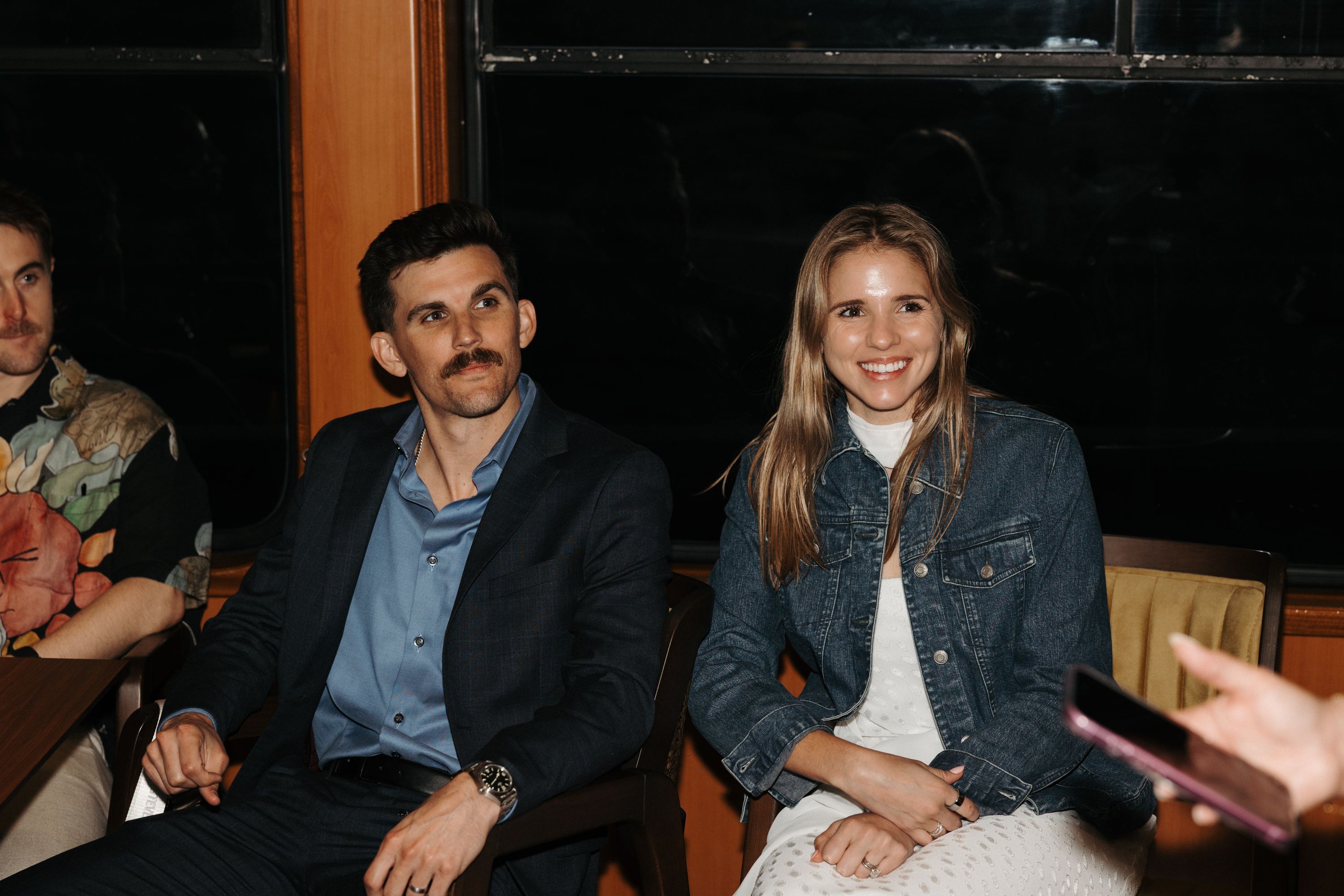 Couple listening to someone talking and holding their phone inside a room