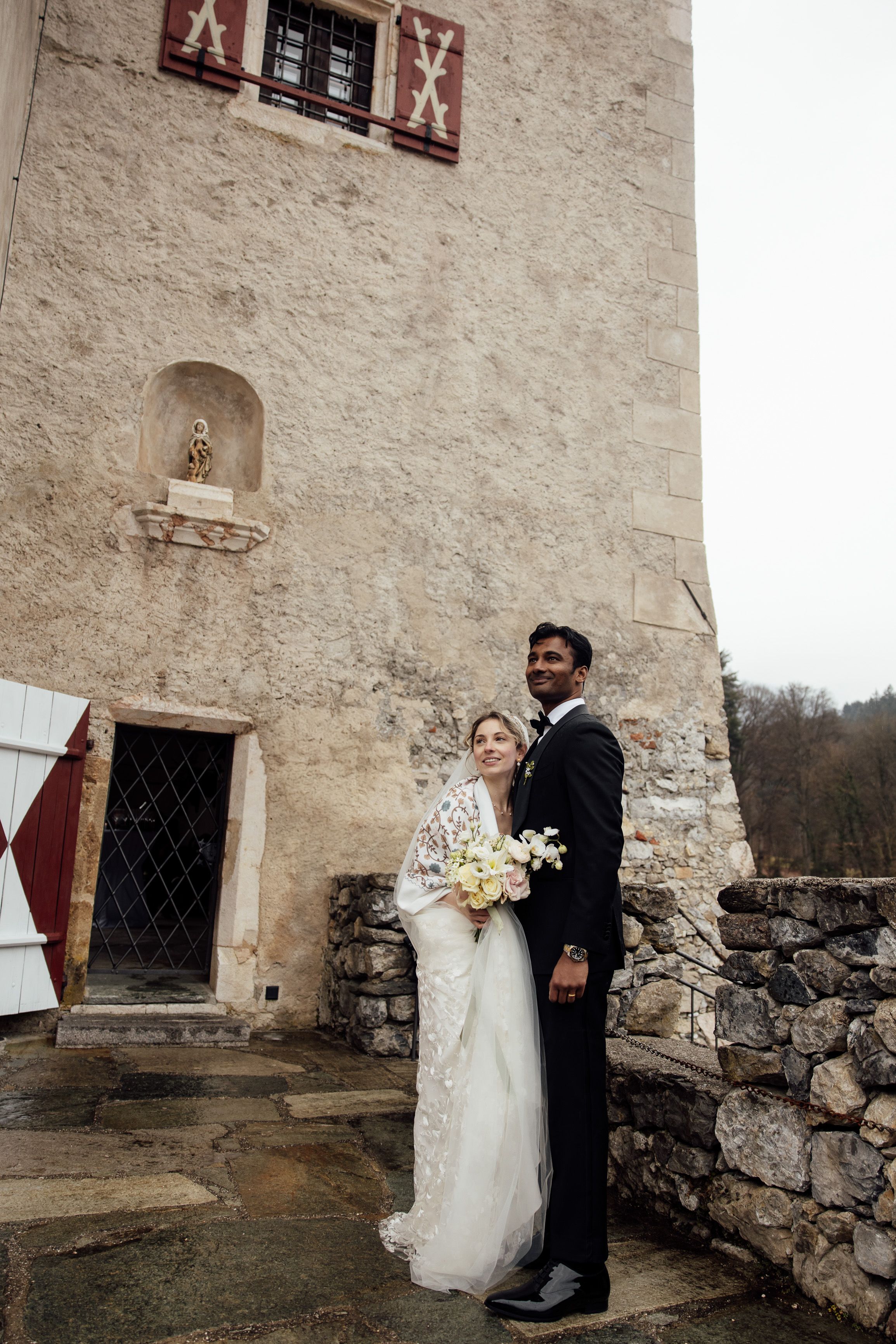 Newlywed couple pose beside historic castle walls following a small wedding in Austria