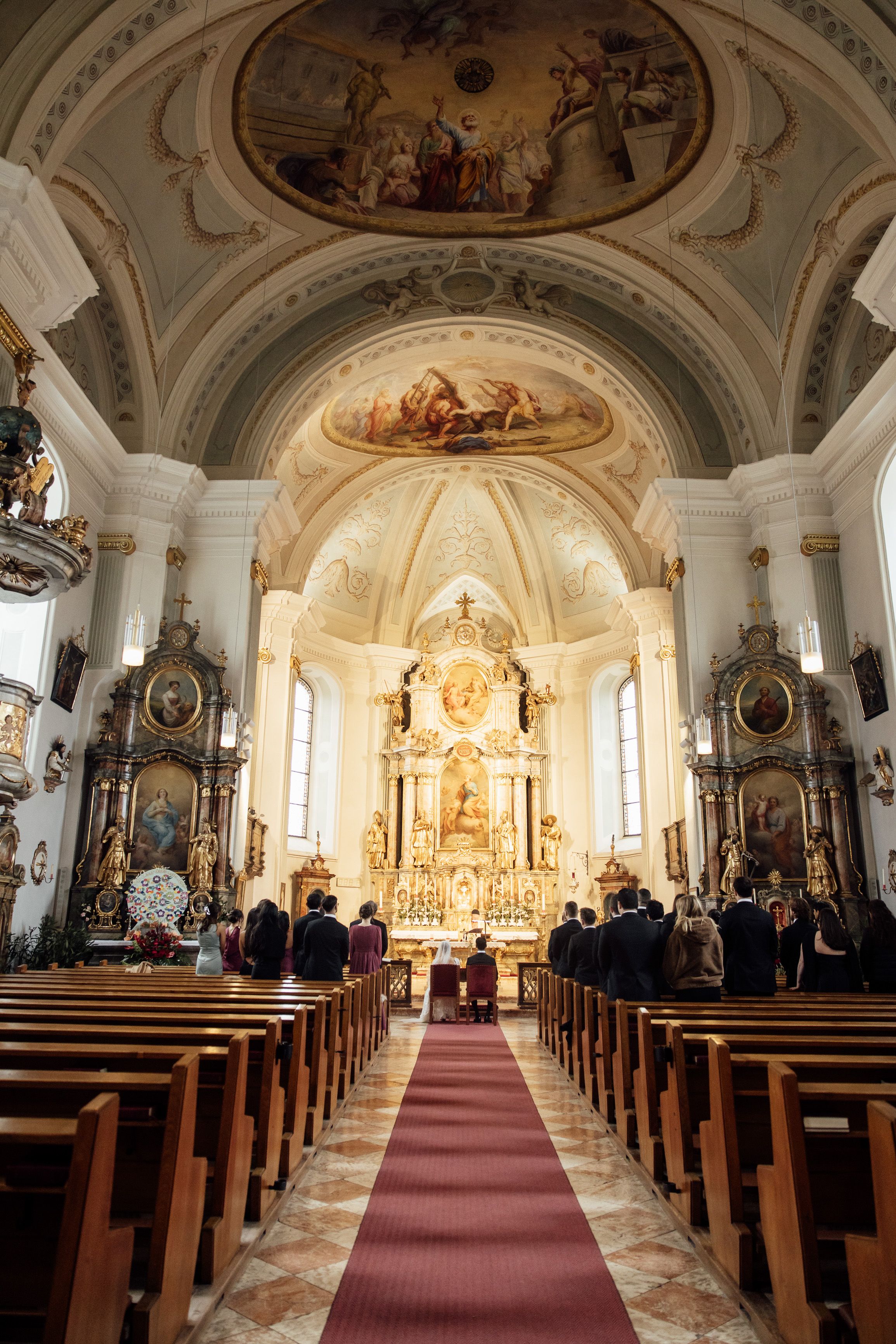Wide view of a historic church ceremony during a small wedding in Austria
