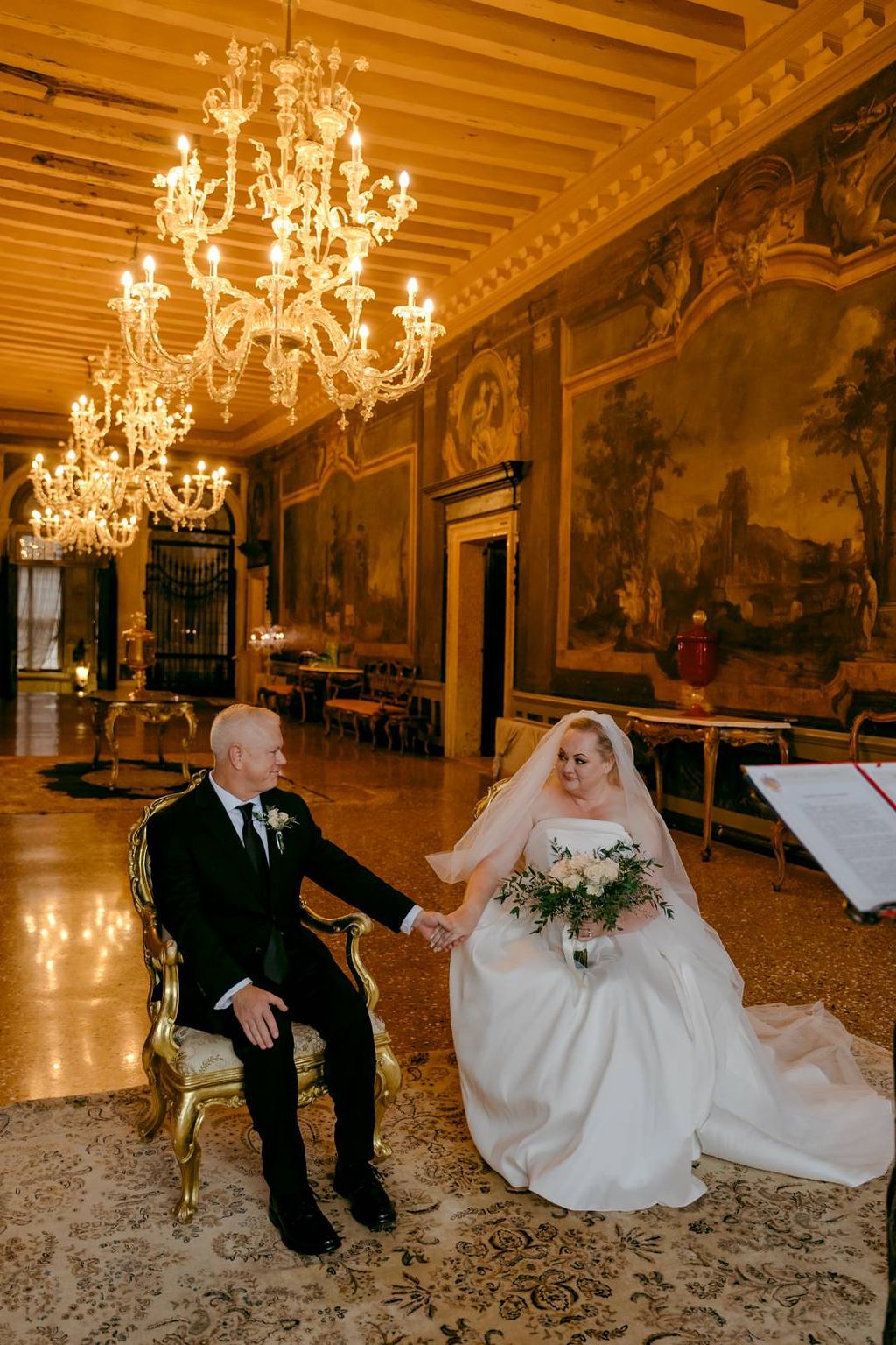Bride and groom having a ceremony in a historic hall of a museum and national monument for their vow renewal in Italy