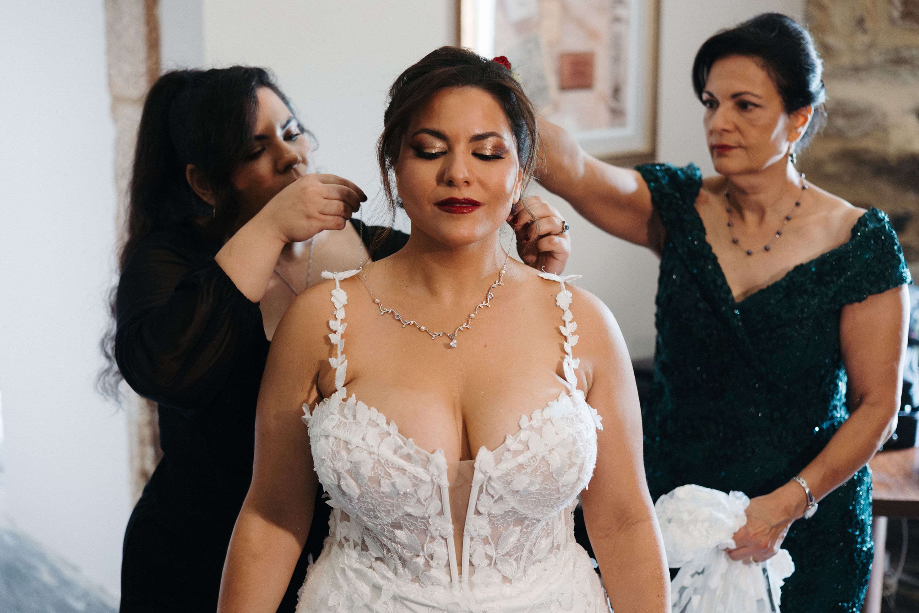 Bride's family members help her get ready for the ceremony of her destination wedding in Portugal