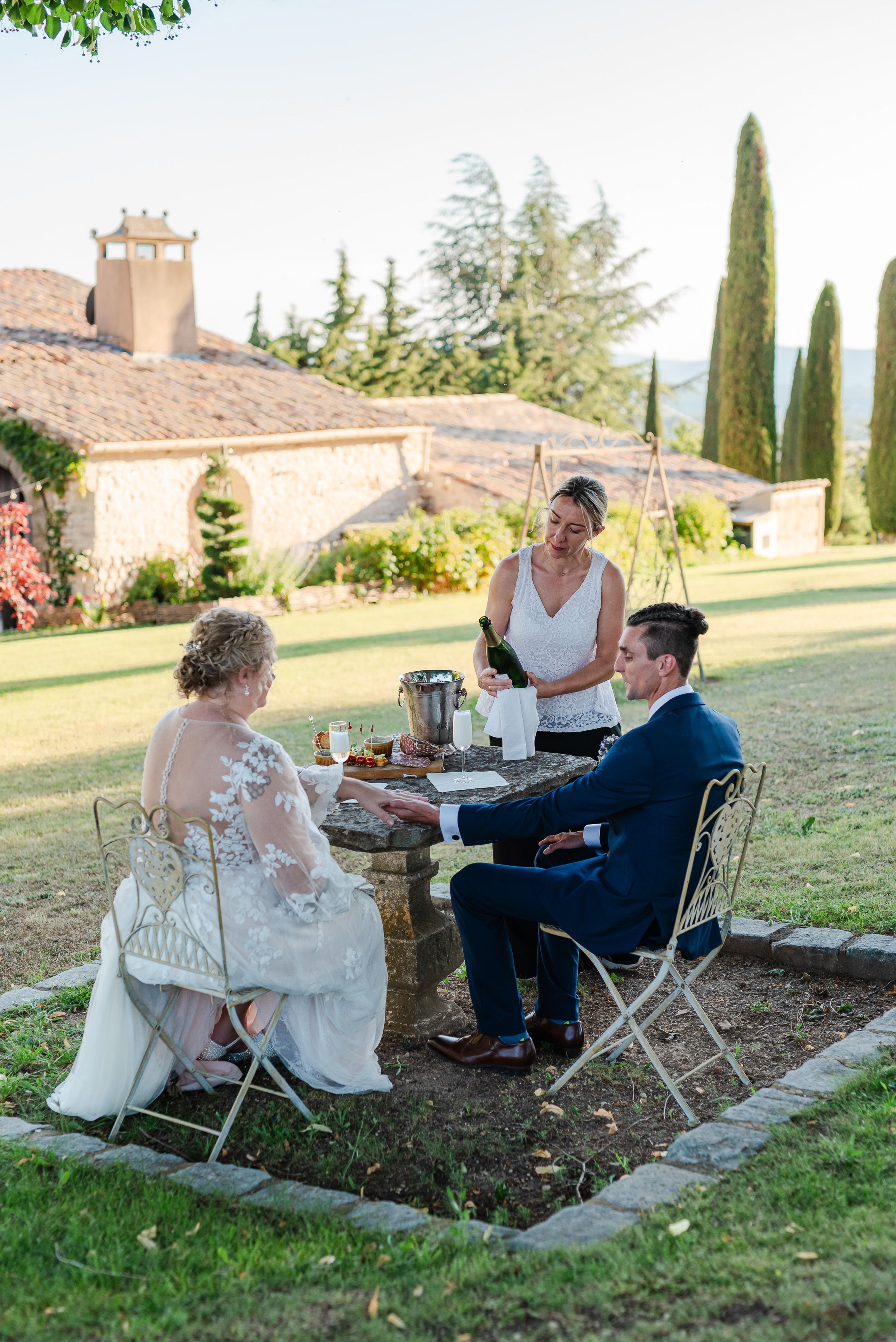 Couple enjoying champagne and appetizers outdoors during a small wedding in France