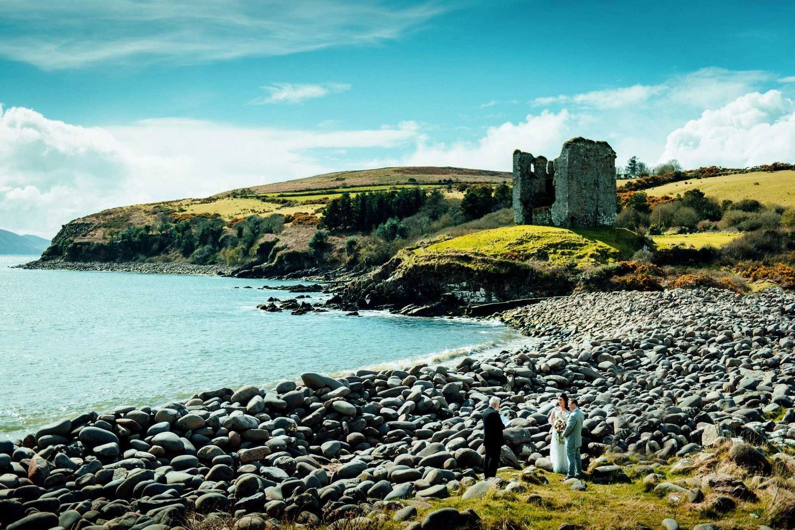 Rocky beach with a castle ruin near Dingle in Ireland