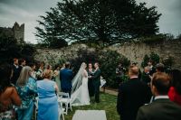 Couple holding hands in front of their guests at a vow renewal in Ireland.