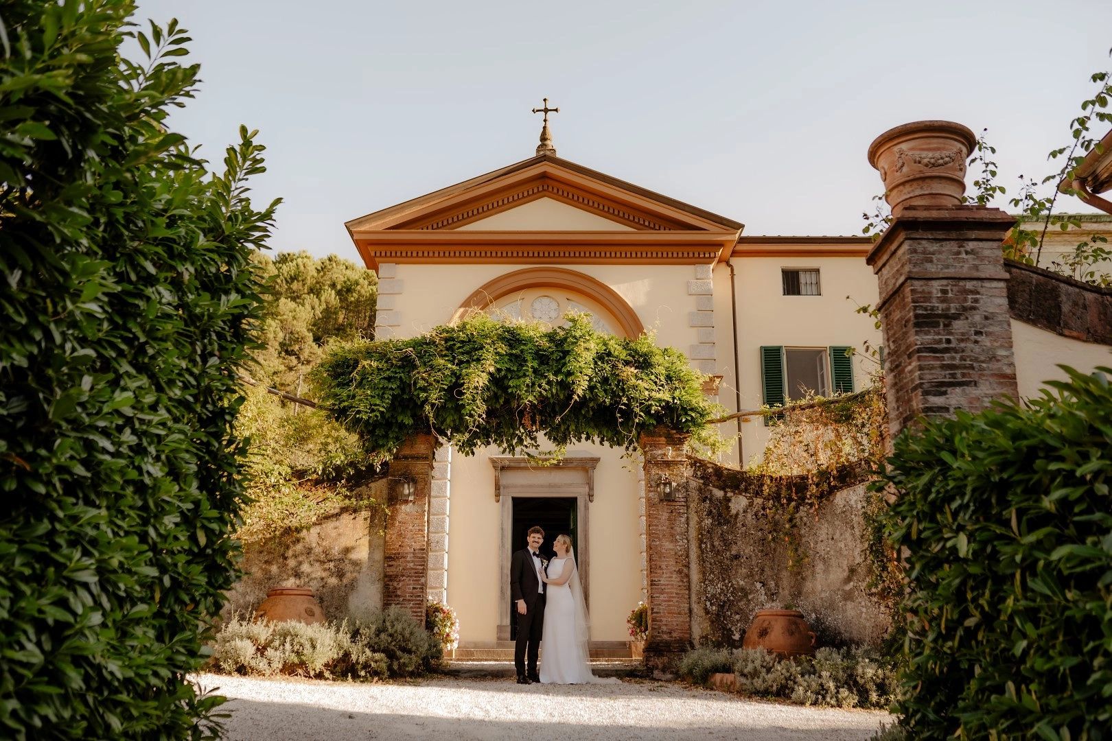 Bride and groom on the door of the chapel where they had a ceremony for their Italian wedding abroad